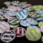 A pile of small buttons with multiple colored WordPress logos on each button.